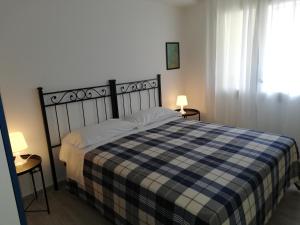 a bedroom with a bed with a blue and white plaid blanket at Akron B&B in SantʼAlessio Siculo
