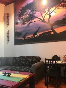 una sala de estar con una pintura de jirafas en la pared en Antaviana Cantabria, en Cabezón de la Sal