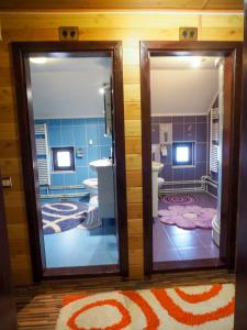 - une salle de bains avec deux miroirs dans une chambre dans l'établissement Vama Casă de vacanţă La marinaru' ratacit, à Vama