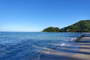 una spiaggia con una cassa d'acqua con alberi sullo sfondo di Thongsom Resort a Khanom Altre 7 foto
