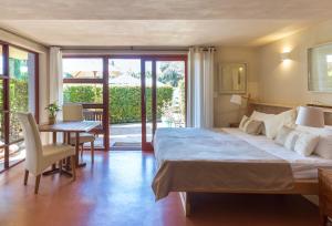 a bedroom with a large bed and a table and chairs at Lézard Bleu Guest House in Cape Town