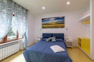 una camera con un letto blu e un dipinto sul muro di Madimà a Sorrento