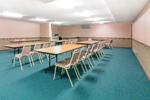 ein Klassenzimmer mit Tischen und Stühlen in einem Raum in der Unterkunft Super 8 by Wyndham Milbank SD in Milbank