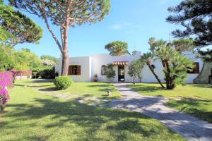 a white house with trees and a grass yard at Villetta con Giardino esclusivo di 1000 mq, Piscina, Tennis, Calcio, Bocce in Forio d'Ischia