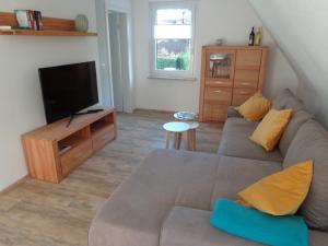 ein Wohnzimmer mit einem Sofa und einem Flachbild-TV in der Unterkunft Ferienwohnung Dawe in Göttingen