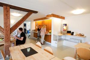 a group of people in a kitchen with a table at Danhostel Frederikshavn City in Frederikshavn