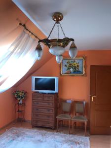 a living room with a tv and a chandelier at Krościenko nad Dunajcem Jagielońska 179/1 in Krościenko
