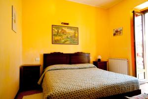 1 dormitorio con 1 cama en una pared amarilla en Agriturismo Monterosso, en Verbania