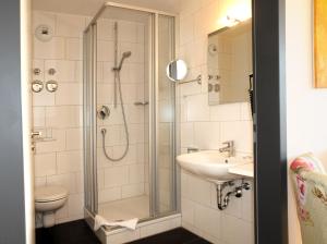 a bathroom with a shower and a sink and a toilet at SEEGER Living Comfort Downtown in Karlsruhe