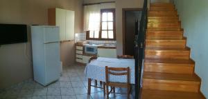 a small kitchen with a table and a refrigerator at Lakonia Bay Apartments in Archangelos