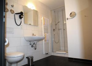 ein Bad mit einem WC, einem Waschbecken und einer Dusche in der Unterkunft SEEGER Living Comfort Downtown in Karlsruhe