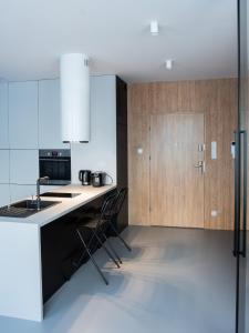 a kitchen with wooden cabinets and a counter top at Ataner Apartamenty in Koszalin