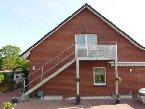 una casa in mattoni rossi con una scala di Ferienwohnung Reins a Neustadt in Holstein
