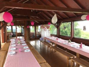 a row of tables in a room with pink plates at Villa Repić in Slatina