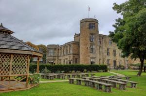 a building with a gazebo and benches in front of it at Best Western Walworth Castle Hotel in Darlington