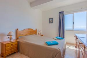 een slaapkamer met een bed met blauwe handdoeken bij Bahia suite in Puerto de Santiago