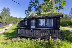 una pequeña casa negra con techo de hierba en Bitigrenda G en Beitostøl