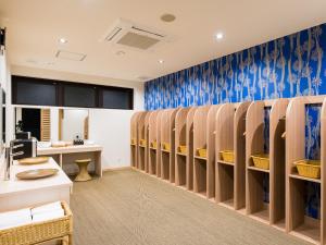 a waiting room with wooden benches and blue wallpaper at Dogo Onsen Yachiyo 道後温泉八千代 in Matsuyama