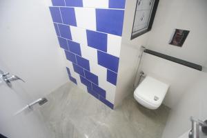 a bathroom with a toilet with blue and white tiles at Mumbai Staytion Dorm- Hostel in Mumbai