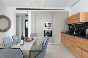 a kitchen with a glass table with chairs and a counter at Luxury 2bdrm balcony & parking close to the Beach in Tel Aviv