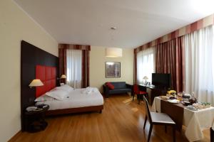 una camera d'albergo con un letto, una scrivania e una stanza di Hotel Guglielmo a Catanzaro