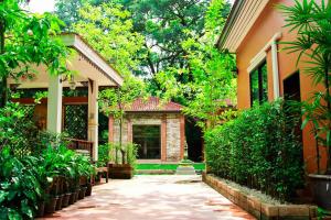 un patio de una casa con árboles y plantas en The Journey House Lifestyle Boutique Hotel, en Kanchanaburi