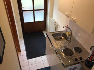 a small kitchen with a sink and a door at Smans Fewo in Neustadt in Holstein
