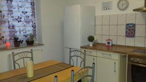 a kitchen with a table and a table and chairs at Ferienwohnung Jacqueline in Tiefensee +5 photos