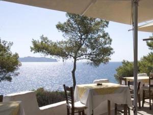 a table and chairs with a view of the water at Agistri Club Hotel in Skliri +18 photos