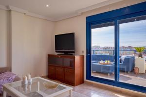 sala de estar con TV de pantalla plana y sofá en iloftmalaga Ático Pacífico 19 C en Málaga