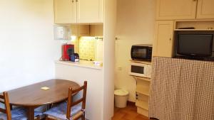 une petite cuisine avec une table et un four micro-ondes dans l'établissement Boost Your Immo Centre Vars 58, à Vars