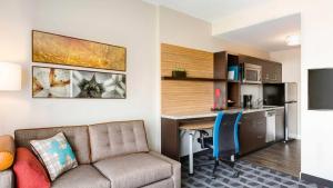 a living room with a couch and a desk and a kitchen at TownePlace Suites by Marriott Kingsville in Kingsville