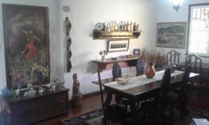 una sala da pranzo con tavolo e sedie e una sala da pranzo di Pousada Dona Denis a Ouro Preto