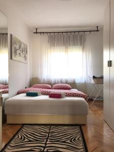 Schlafzimmer mit einem großen Bett und einem Fenster in der Unterkunft Zg Zapad in Zagreb