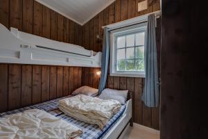 um pequeno quarto com 2 camas e uma janela em Bitigrenda F em Beitostøl