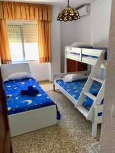 een slaapkamer met 2 stapelbedden en een kroonluchter bij ALBAIDA II 2B MENYBER in Nerja