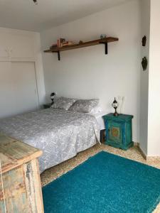 een slaapkamer met een bed en een blauwe nachtkastje bij ALBAIDA II 2B MENYBER in Nerja
