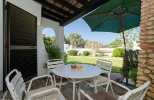 カルヴォエイロにある2 Bedroom Villa with Garden Viewのパティオ(テーブル、椅子、パラソル付)
