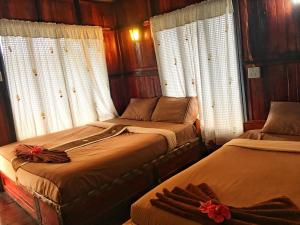 two beds in a room with wooden walls and windows at Phi Phi Green Hill Resort in Phi Phi Don +37 photos