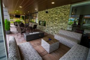 un restaurante con sofás, mesa y sillas en Hotel Regina Resort & Convenciones, en Cochabamba