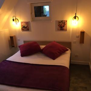a bedroom with a bed with two red pillows at le 2018 in Cancale