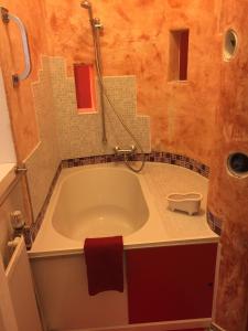 ベルリンにあるAppartement am Tegeler Seeのバスルーム(バスタブ、赤いタオル付)