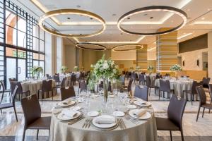 a banquet hall with tables and chairs and chandeliers at Barceló Cáceres V Centenario in Cáceres