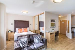 1 dormitorio con cama, sofá y escritorio en House of Fisher - Central House en Camberley