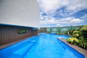a large blue swimming pool next to a building at Grand China Bangkok in Bangkok