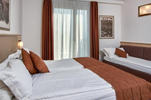 a hotel room with two beds and a window at Hotel Le Balze - Aktiv & Wellness in Tremosine Sul Garda