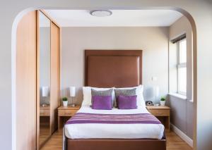 a bedroom with a large bed with purple pillows at House of Fisher - City Wall House in Reading