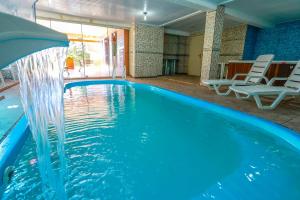 a swimming pool with a water fountain at SKY VALLE HOTEL - Com vista privilegiada para o Vale do Quilombo in Gramado