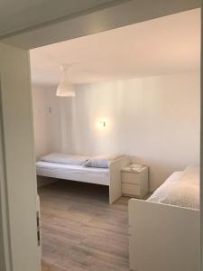 a small room with two beds in a room at Pension QMT Reutlingen in Reutlingen