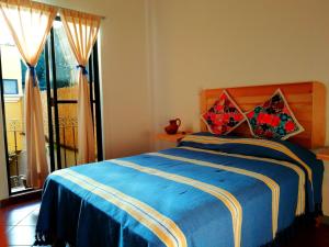 瓦哈卡市Casa Gecko的一间卧室配有蓝色的床和两个枕头